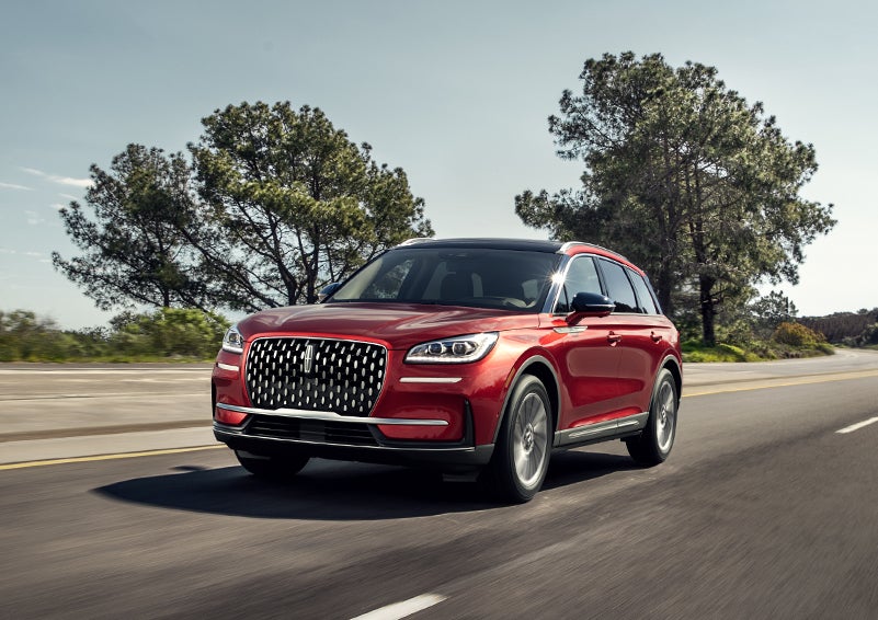 A 2024 Lincoln Corsair® SUV is shown being driven on a country road. | Apple Lincoln Apple Valley in Apple Valley MN