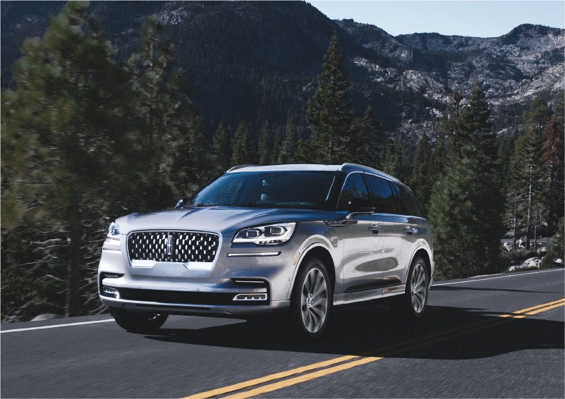 A 2023 Lincoln Aviator® Grand Touring SUV being driven on a winding road to demonstrate the capabilities of all-wheel drive | Apple Lincoln Apple Valley in Apple Valley MN