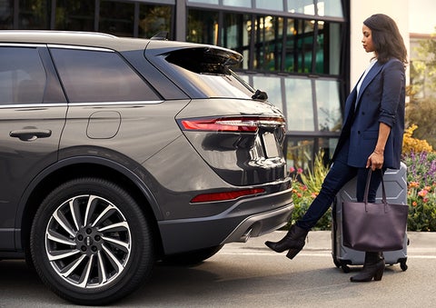 A woman with her hands full uses her foot to activate the available hands-free liftgate. | Apple Lincoln Apple Valley in Apple Valley MN