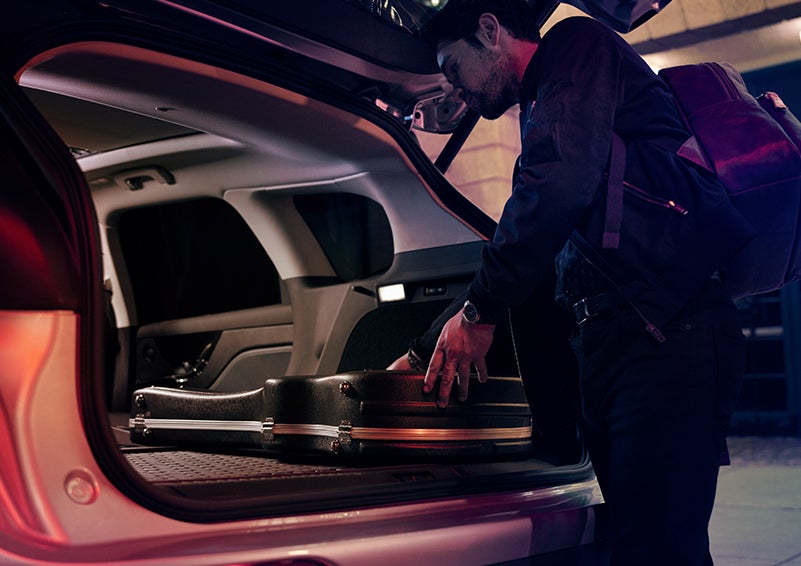 A man is shown loading cargo into the rear of a 2024 Lincoln Corsair® SUV with the second-row seats folded flat. | Apple Lincoln Apple Valley in Apple Valley MN