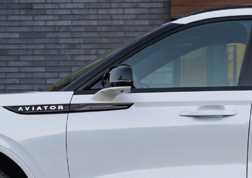 The driver’s side door and fender badging of a white 2026 Lincoln Aviator® SUV are showcased. | Apple Lincoln Apple Valley in Apple Valley MN