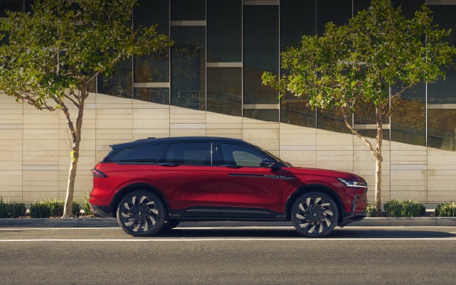 A 2026 Lincoln Nautilus® SUV with an available Hybrid Powertrain is parked in an urban setting. | Apple Lincoln Apple Valley in Apple Valley MN