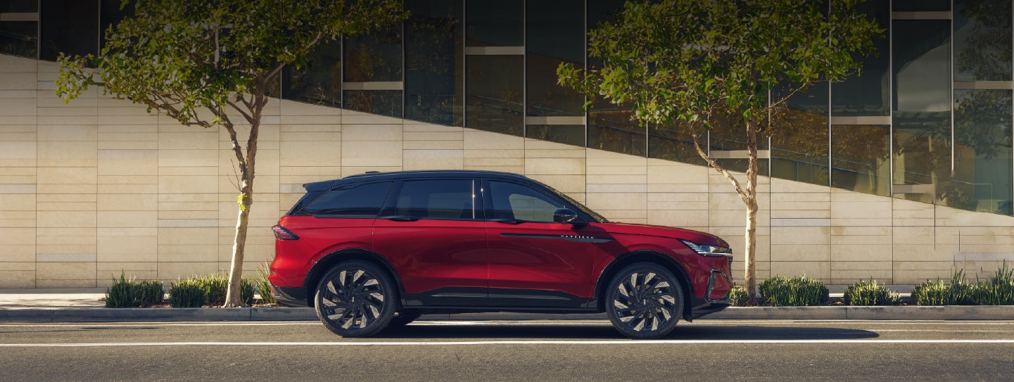 A 2026 Lincoln Nautilus® SUV with an available Hybrid Powertrain is parked in an urban setting. | Apple Lincoln Apple Valley in Apple Valley MN