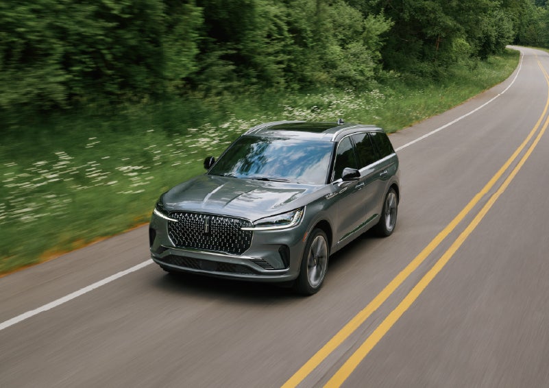 A 2027 Lincoln Aviator® SUV is being driven down a road. | Apple Lincoln Apple Valley in Apple Valley MN