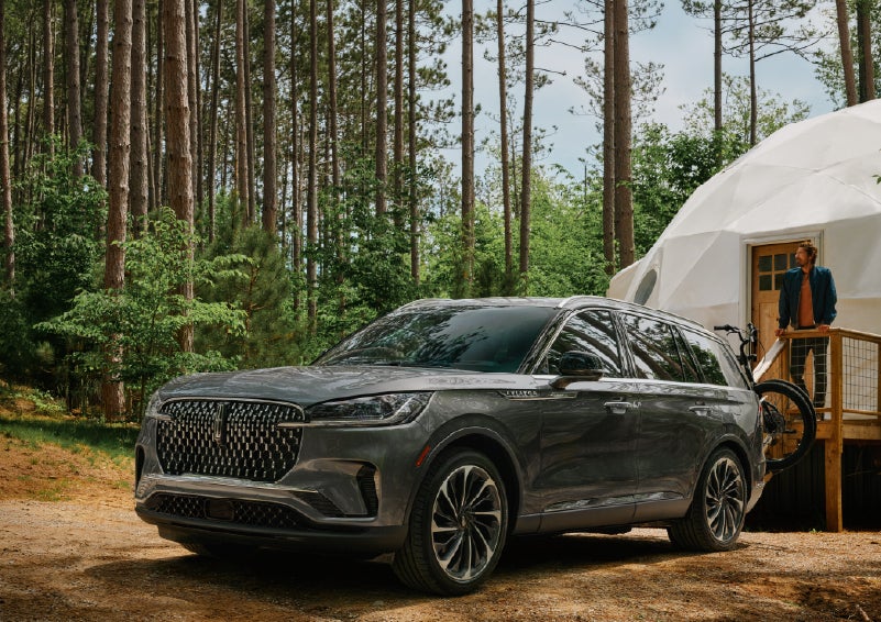 A 2027 Lincoln Aviator® is parked next to a high end glamping site. | Apple Lincoln Apple Valley in Apple Valley MN