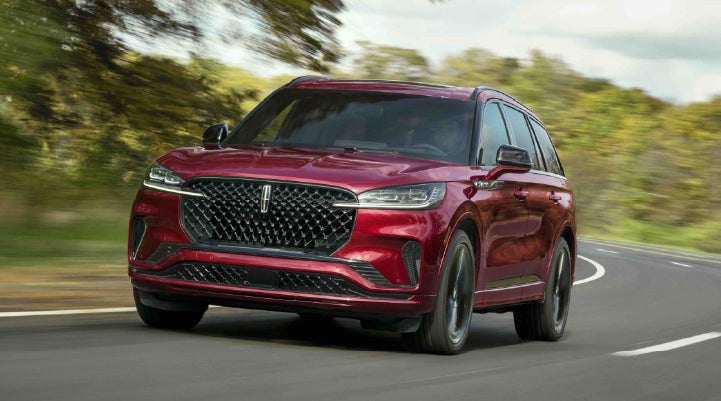 A 2027 Lincoln Aviator® SUV is being driven on a country road | Apple Lincoln Apple Valley in Apple Valley MN