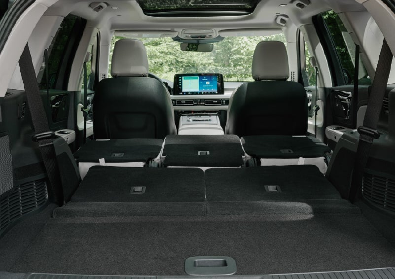 A rear to front view of the interior of a 2027 Lincoln Aviator® Black Label™ SUV shows the third and second rows folded flat | Apple Lincoln Apple Valley in Apple Valley MN